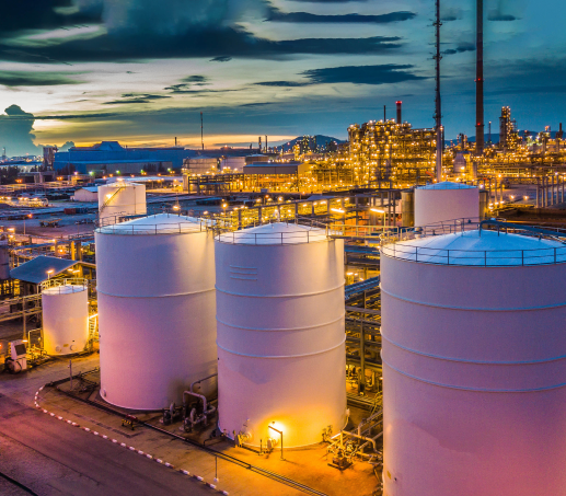 Oil & Gas refinery at dusk with lights on that uses digital twin
